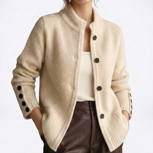 Close view of the beige moss-stitch cardigan with black buttons on the front and cuffs