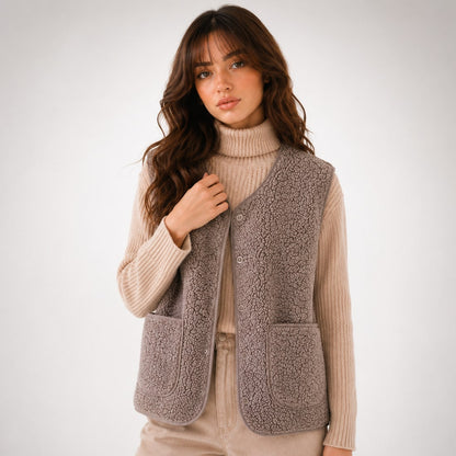 Woman wearing the taupe teddy sherpa vest with small buttons and patch pockets
