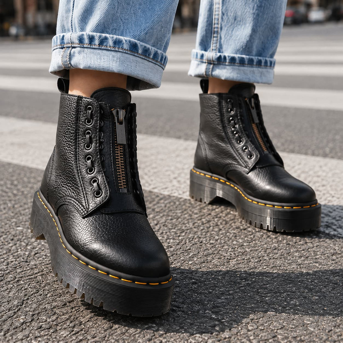Black chunky platform ankle boots with front zip, worn with cuffed jeans 1