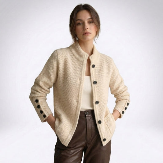 Woman wearing a beige textured knit button cardigan with a high stand collar and black buttons