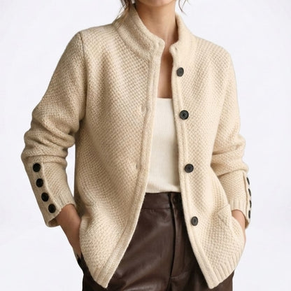 Close view of the beige moss-stitch cardigan with black buttons on the front and cuffs
