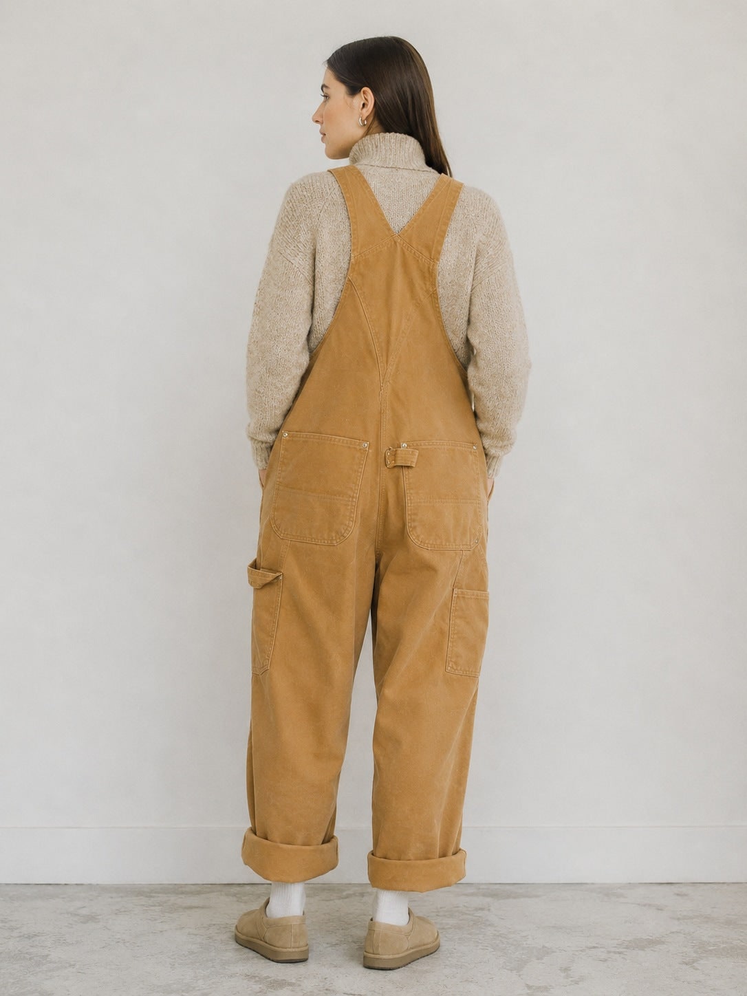 Beige canvas bib overalls, back view with cuffed legs 2
