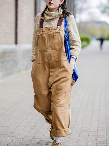 Beige canvas dungarees worn on the street with a bag 4