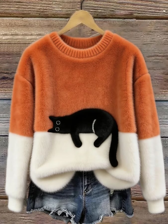 Orange and white cat print sweater on a hanger 1