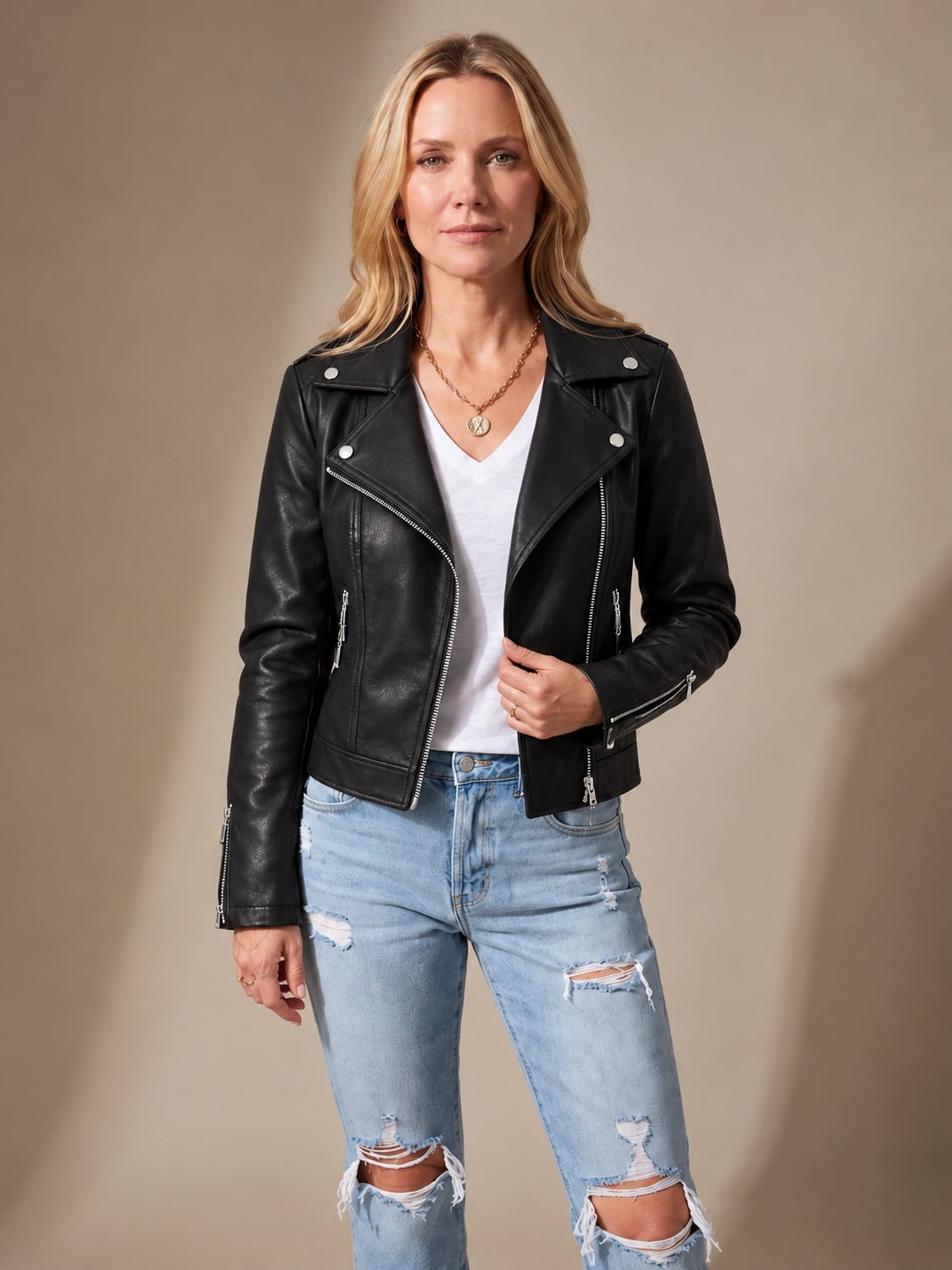 Black faux leather asymmetric zip moto jacket worn with a white tee and ripped jeans 1